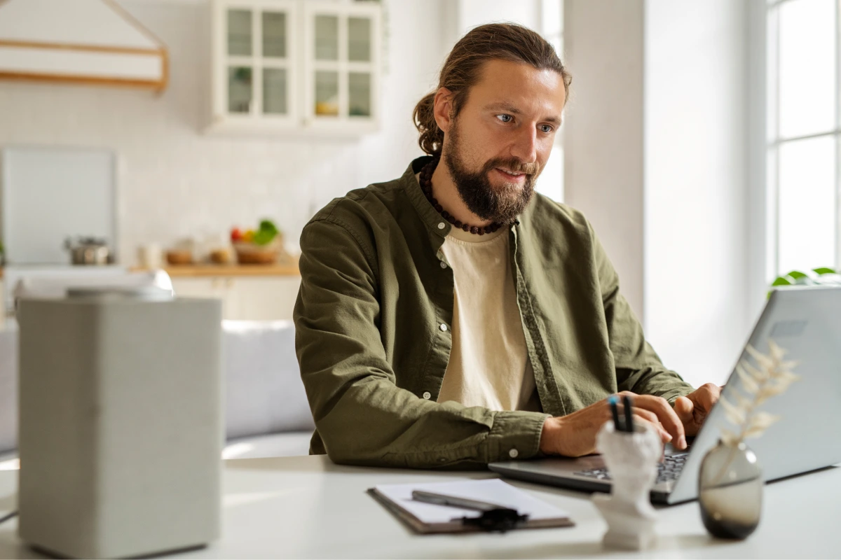 side-view-smiley-man-working-laptop 1